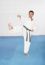 Man In A Kimono Hits With Foot And Hand.  Karate Concept