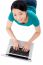 Young Woman Lying On Floor Using Laptop