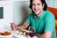 Young Smiling Man Eating At Restaurant