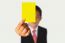 Businessman Showing Yellow Paper