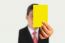 Businessman Showing Yellow Paper