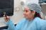 Happy Female Surgeon Reading Message At Mobile Phone