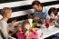 Family Of Four Having Meal In Restaurant