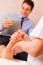 Masseuse Massaging Businessman's Foot