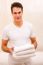 Young Man Holding Stack Of Fresh Towels