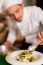 Chef Arranging Tossed Salad In A White Bowl