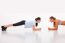 Two Happy Young Woman Doing Push-ups In Gym