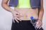 Woman After Fitness Training, Pinches Fat On The Belly