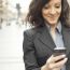 Businesswoman With Smartphone Walking On Street