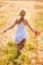 Happy Young Blonde Girl In White Dress With Straw Hat Running Th