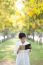 Portrait Of Young Beautiful Asian Woman Standing In Yellow Flowe