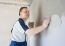 Middle-aged Man Worker Putting Plaster On The Wall