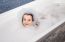 Little Girl Lying In A Bath With Soap Suds