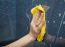 Female Hand Washes The Tile On The Wall With A Cloth Lather