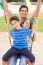 Father And Children Enjoying Swing Ride