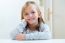 Beautiful Blonde Child Sitting At A Table In Kitchen