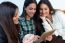 Three Young Woman Using Digital Tablet At Cafe Shop