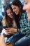 Three Young Woman Using Mobile Phone At Cafe Shop