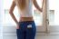 Young Beautiful Woman At Home With Mobile Phone In Back Pocket