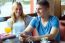 Group Of Friends Using Mobile Phone In Cafe