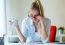 Young Beautiful Woman Holding A Cup Of Coffee And Reading Newspa