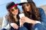 Two Girls Having Fun With Smartphones