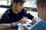 Group Of Friends Using Mobile Phone In Cafe