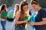 A Group Of Students Having Fun With Smartphones After Class