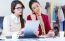 Two Young Businesswomen Working With Digital Tablet In Her Offic