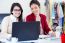 Two Young Businesswomen Working With Laptop In Her Office