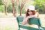 Asian Women Sitting On A Bench In The Park