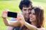 Happy Young Couple With Smartphone At The Park