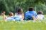 Happy Young Family Lying On Grass