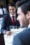 Two Smiling Business Men Have Dinner At Restaurant