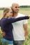 Young Couple In Meadow With The Hands In The Air, Hugging