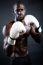 Young Athletic Boxer Wearing Gloves In Black Background