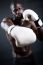 Young Athletic Boxer Wearing Gloves In Black Background