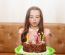 Little Girl Blowing Out The Candles On A Birthday Cake