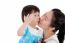 Asian Mother Carrying And Smooching Her Daughter On White Background