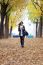 Beautiful Girl Walking With Mobile Phone In Autumn