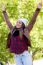 Portrait Of Beautiful Girl Standing In Autumn Field With Arms Ra