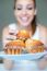 Happy Young Woman Eating Delicious Muffins