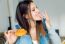 Beautiful Young Woman Eating Donuts At Home