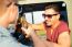 Portrait Of Two Friends Toasting With Bottles Of Beer In Car