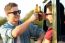 Portrait Of Two Friends Toasting With Bottles Of Beer In Car