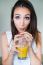 Smiling Woman Drinking Orange Juice At Home