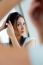 Young Beautiful Woman Making Hairstyle Near Mirror