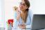 Pretty Young Woman Eating An Apple In Her Office