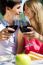 Attractive Couple Drinking Wine On Romantic Picnic In Countrysid