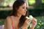 Young Beautiful Woman Eating Piece Of Melon In The Garden